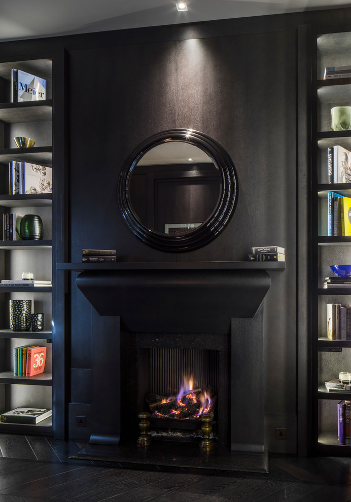 ロンドンにあるラグジュアリーな中くらいなトラディショナルスタイルのおしゃれな書斎 (茶色い壁、濃色無垢フローリング、標準型暖炉、石材の暖炉まわり、自立型机) の写真