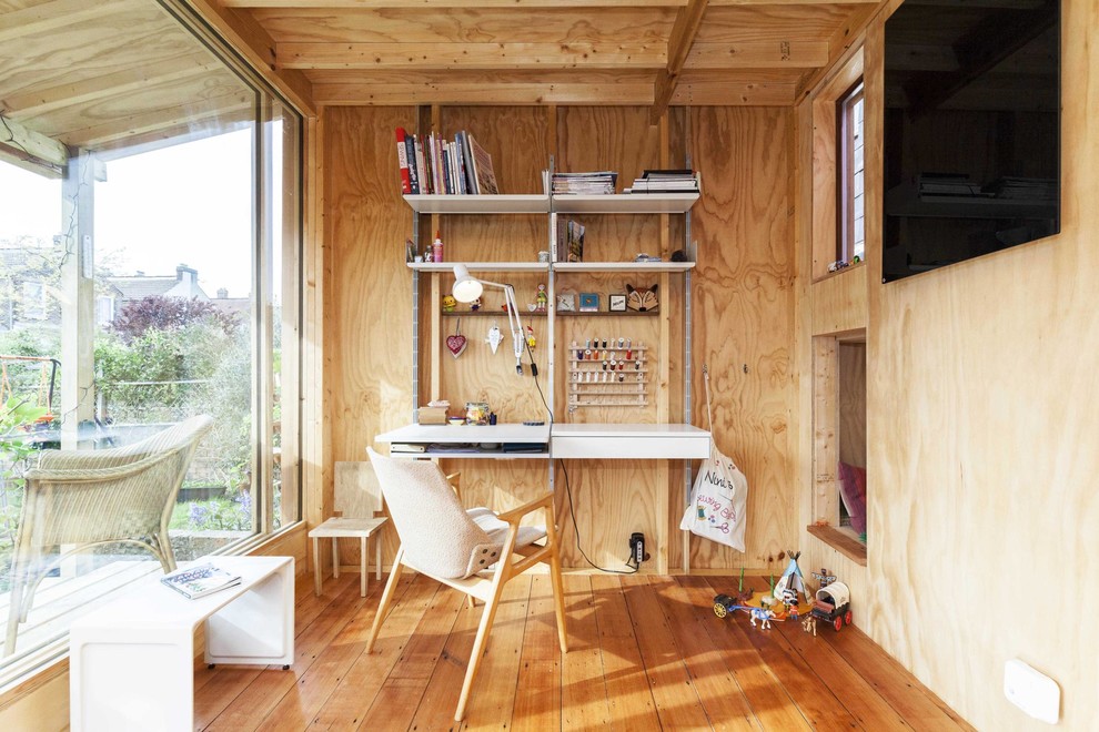 Foto de despacho de estilo de casa de campo con suelo de madera en tonos medios y escritorio empotrado