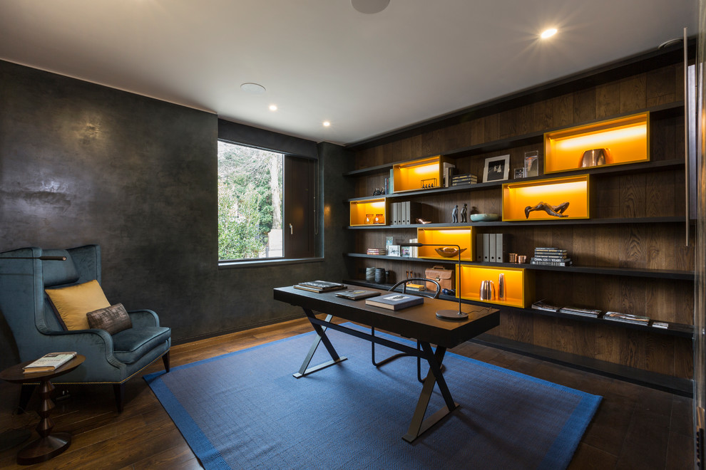 На фото: кабинет среднего размера в стиле неоклассика (современная классика) с темным паркетным полом, отдельно стоящим рабочим столом, коричневым полом и черными стенами с