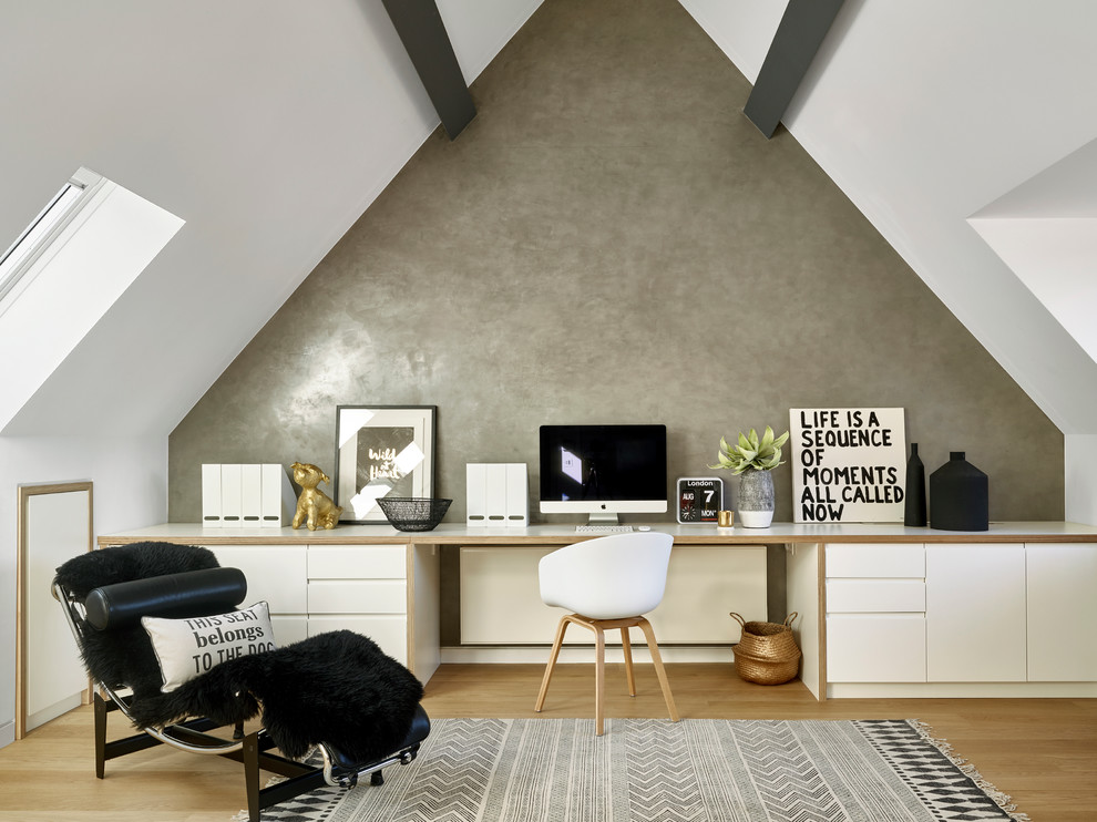 Modernes Arbeitszimmer mit Arbeitsplatz, grauer Wandfarbe, hellem Holzboden und Einbau-Schreibtisch in London