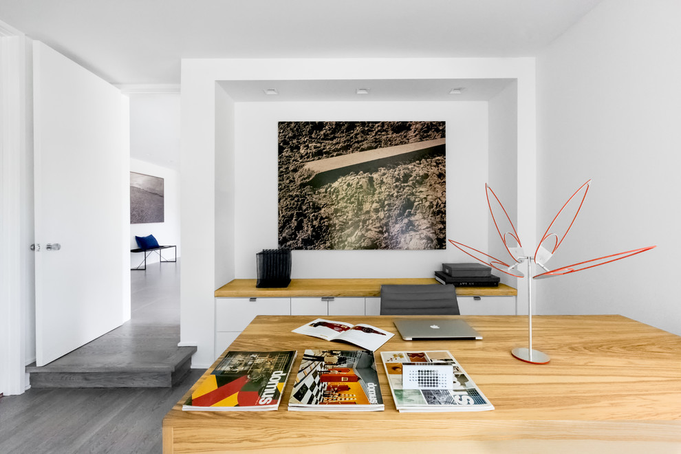 Exempel på ett stort modernt hemmastudio, med vita väggar, mellanmörkt trägolv, ett fristående skrivbord och grått golv