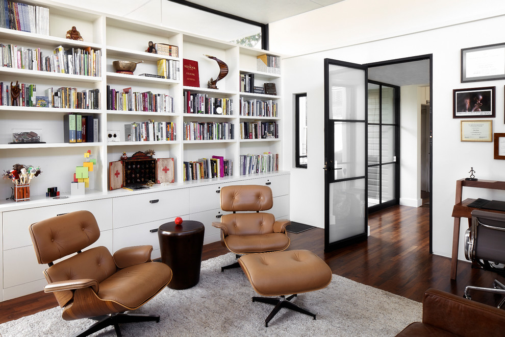 Mittelgroßes Modernes Arbeitszimmer ohne Kamin mit weißer Wandfarbe, dunklem Holzboden, Arbeitsplatz, freistehendem Schreibtisch und braunem Boden in Austin