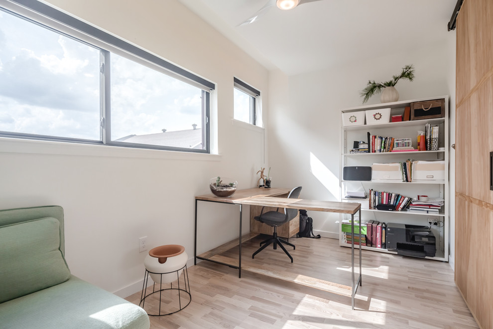Example of a small danish freestanding desk light wood floor and beige floor study room design in Philadelphia with white walls and no fireplace
