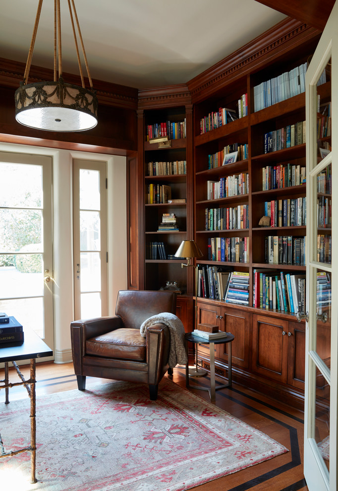 Foto de despacho mediterráneo con biblioteca, paredes marrones, suelo de madera en tonos medios, escritorio independiente y suelo marrón