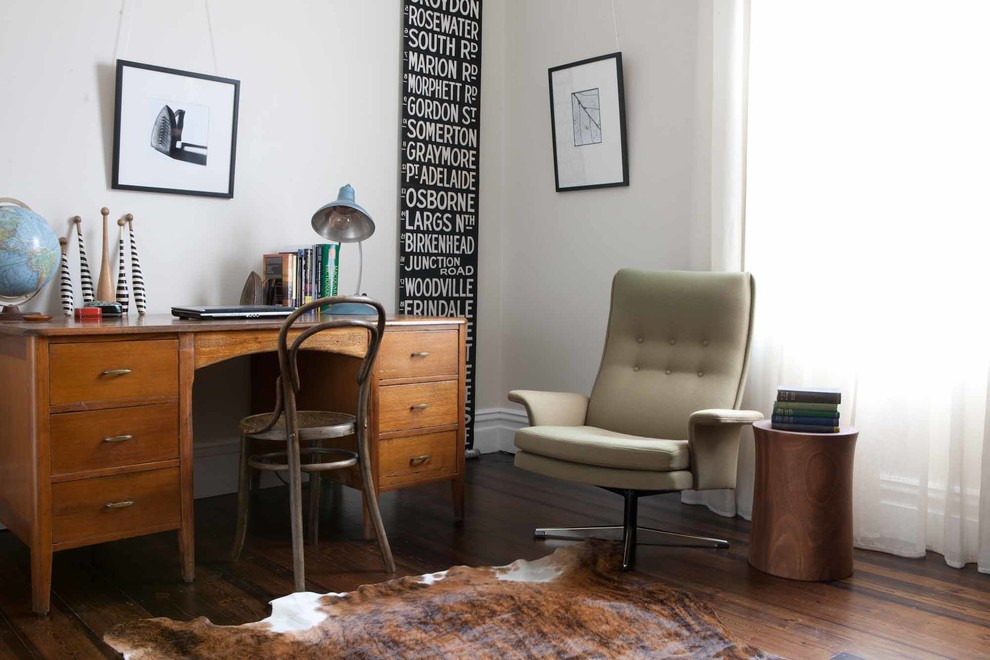Mid-Century Arbeitszimmer mit Arbeitsplatz, weißer Wandfarbe, dunklem Holzboden und freistehendem Schreibtisch in Adelaide