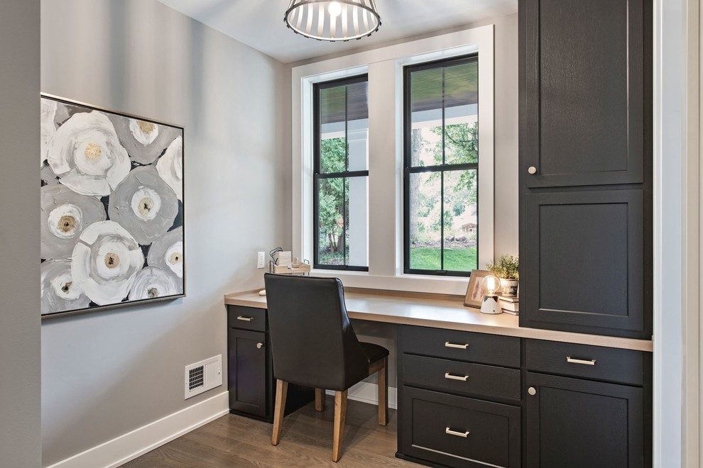 Imagen de despacho clásico renovado de tamaño medio sin chimenea con paredes grises, suelo de madera en tonos medios, escritorio empotrado y suelo beige
