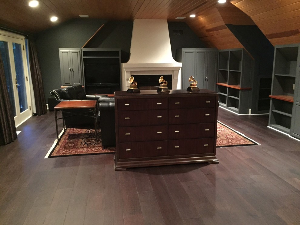 Photo of a large contemporary home studio in Minneapolis with green walls, dark hardwood flooring, a standard fireplace, a plastered fireplace surround and a built-in desk.