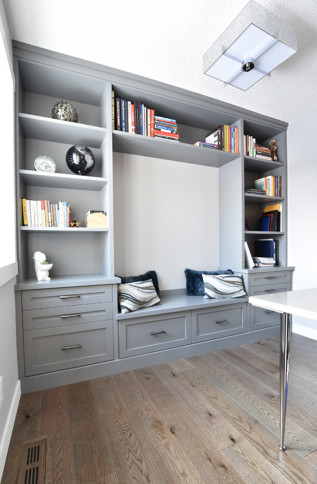 Aménagement d'un bureau classique de taille moyenne avec un mur bleu, un sol en bois brun, un bureau intégré, aucune cheminée et un sol marron.