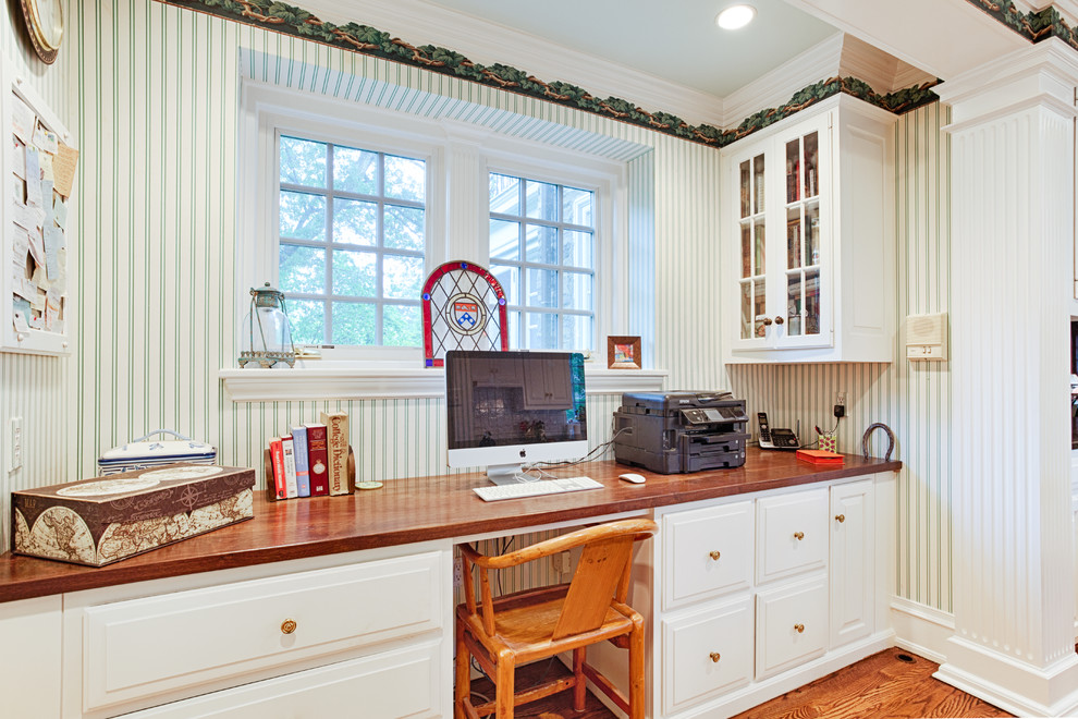 Ejemplo de despacho tradicional de tamaño medio con paredes blancas, suelo de madera clara y escritorio empotrado