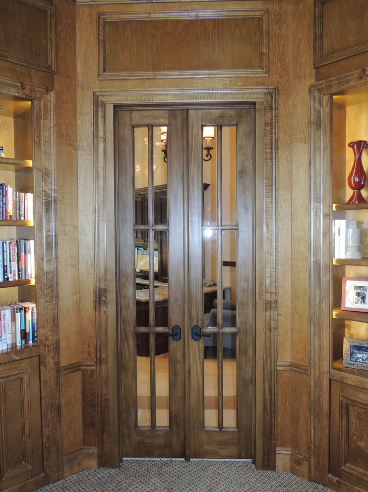 Inspiration för stora klassiska hemmabibliotek, med beige väggar och ett inbyggt skrivbord