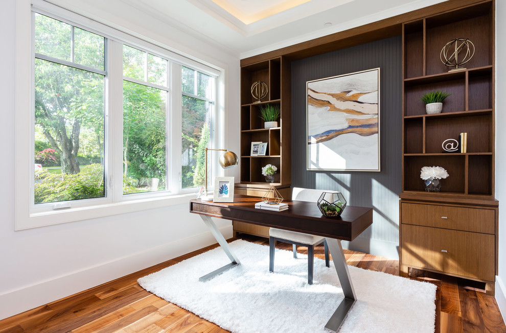 Diseño de despacho moderno de tamaño medio sin chimenea con paredes multicolor, suelo de madera en tonos medios, escritorio independiente y suelo marrón