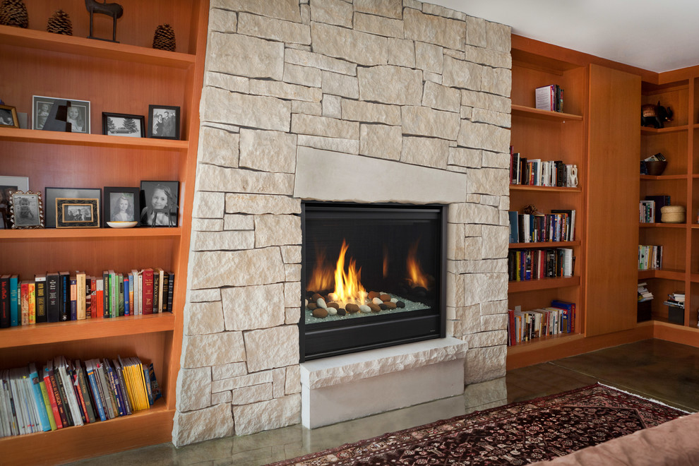 ボルチモアにある広いミッドセンチュリースタイルのおしゃれなホームオフィス・書斎 (ライブラリー、コンクリートの床、標準型暖炉、石材の暖炉まわり、グレーの床) の写真