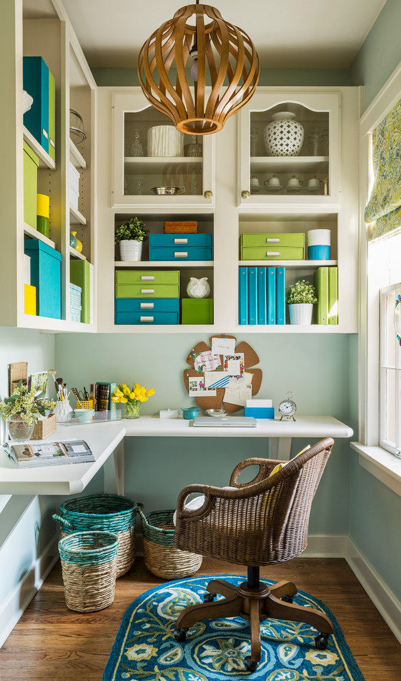 Inspiration for a mid-sized transitional built-in desk dark wood floor craft room remodel in Little Rock with blue walls and no fireplace