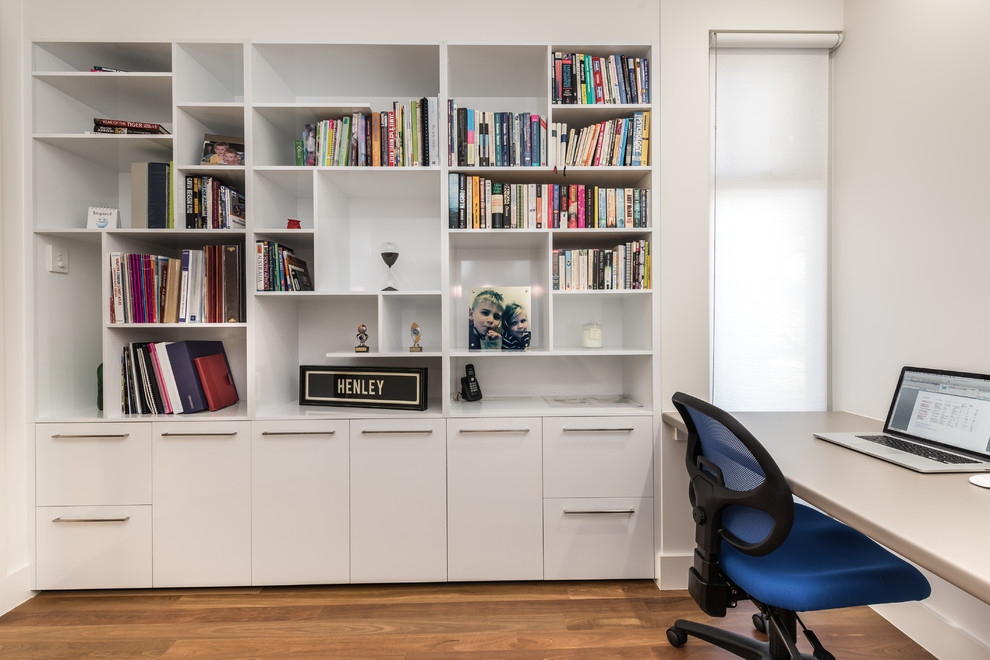 Idee per un ufficio minimal di medie dimensioni con pareti bianche, pavimento in legno massello medio, nessun camino e scrivania incassata