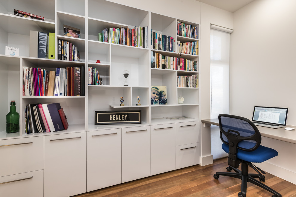 アデレードにある低価格の中くらいなコンテンポラリースタイルのおしゃれな書斎 (白い壁、無垢フローリング、暖炉なし、造り付け机) の写真