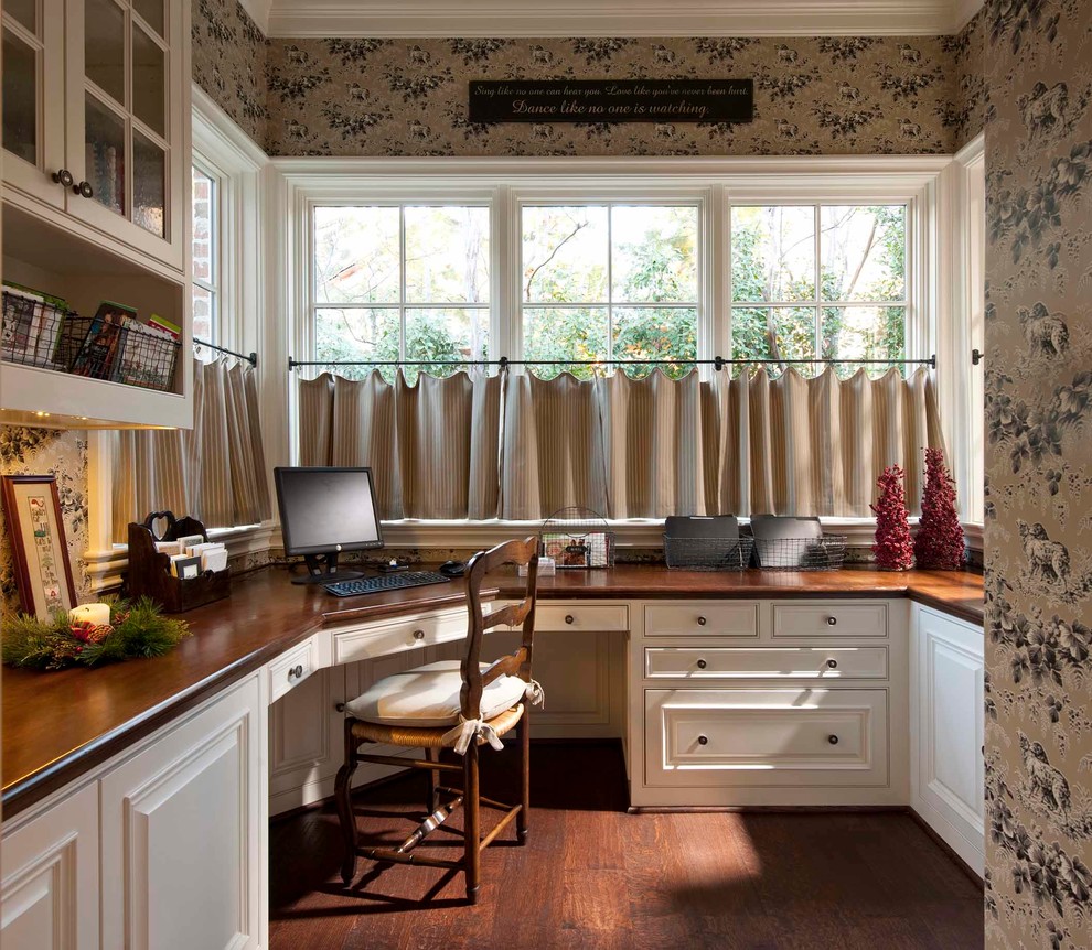 Ejemplo de despacho clásico pequeño con suelo de madera oscura, escritorio empotrado y suelo marrón