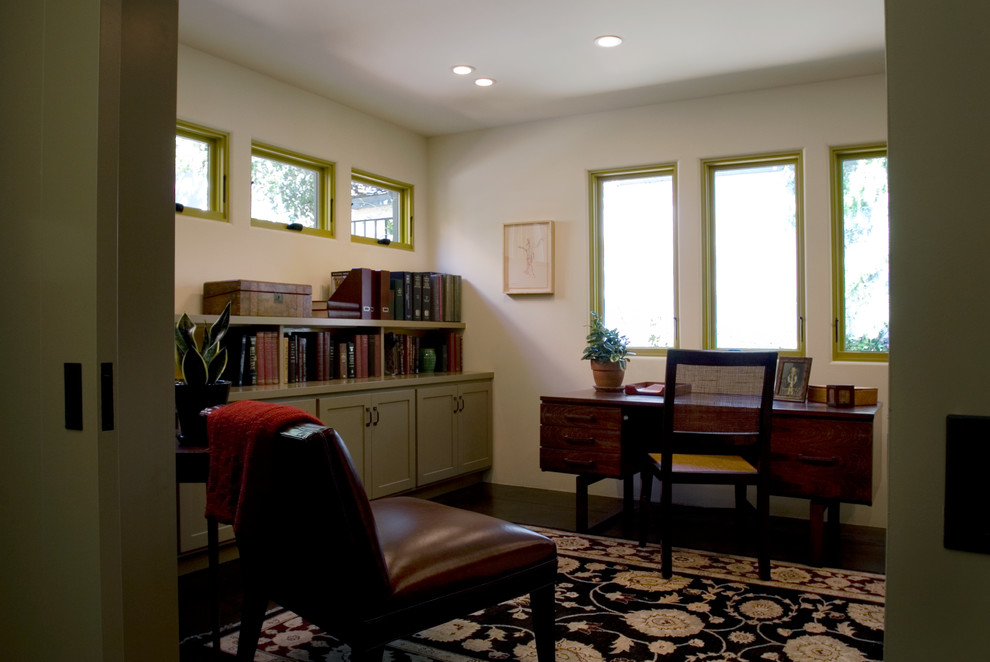 Ejemplo de despacho bohemio de tamaño medio con paredes blancas, suelo de cemento, escritorio independiente y suelo negro
