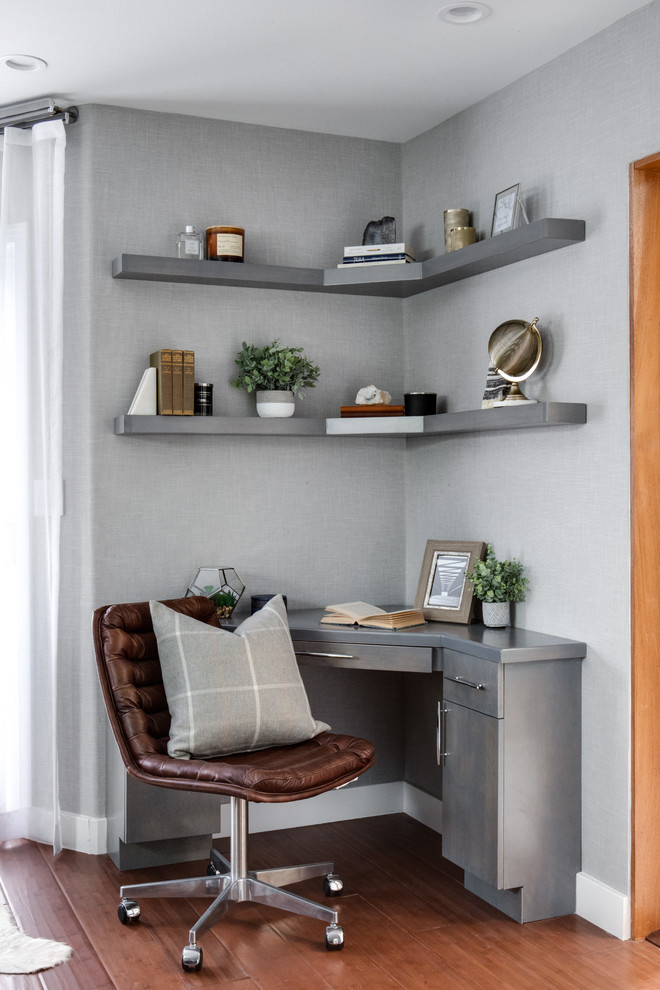 На фото: маленькое рабочее место в стиле модернизм с серыми стенами, темным паркетным полом, встроенным рабочим столом и коричневым полом без камина для на участке и в саду