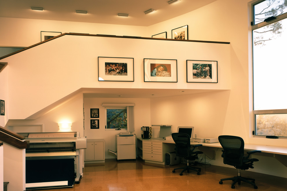 Geräumiges Modernes Arbeitszimmer ohne Kamin mit Arbeitsplatz, weißer Wandfarbe, Betonboden und Einbau-Schreibtisch in Los Angeles