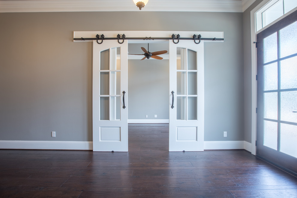This is an example of a medium sized classic study in Houston with beige walls, dark hardwood flooring and brown floors.
