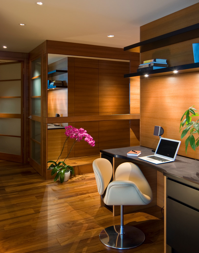 Ejemplo de despacho actual de tamaño medio con suelo de madera en tonos medios, escritorio empotrado y suelo marrón