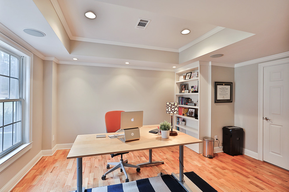 Mittelgroßes Klassisches Arbeitszimmer ohne Kamin mit Arbeitsplatz, grauer Wandfarbe, hellem Holzboden und freistehendem Schreibtisch in Atlanta