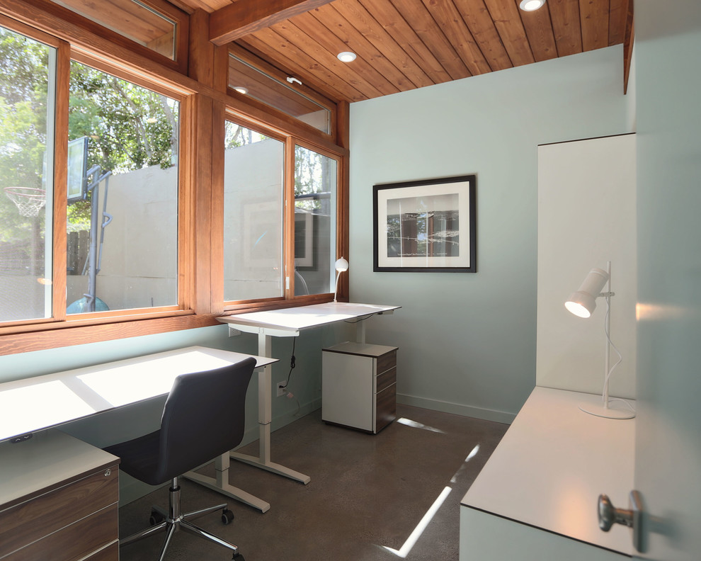 Idéer för ett mellanstort 50 tals hemmastudio, med blå väggar, betonggolv, ett inbyggt skrivbord och grått golv