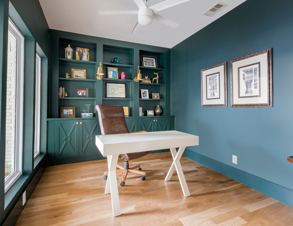 Classic study in Dallas with light hardwood flooring, no fireplace, a freestanding desk, beige floors and blue walls.