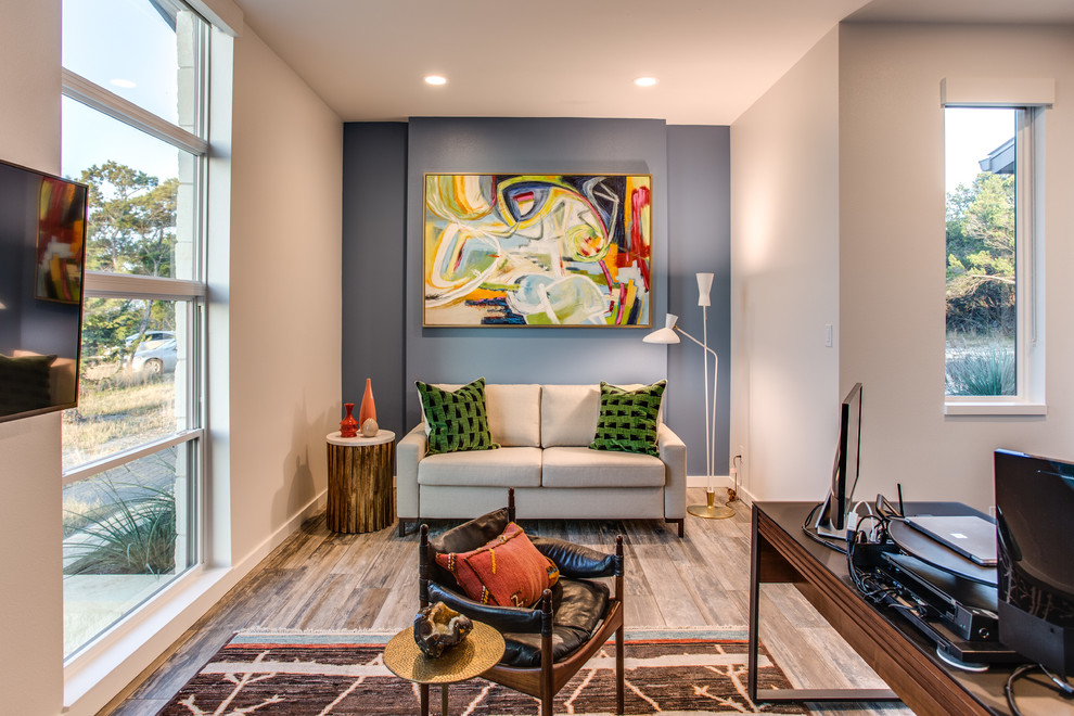 Mittelgroßes Modernes Arbeitszimmer mit Porzellan-Bodenfliesen, freistehendem Schreibtisch, braunem Boden und blauer Wandfarbe in Austin