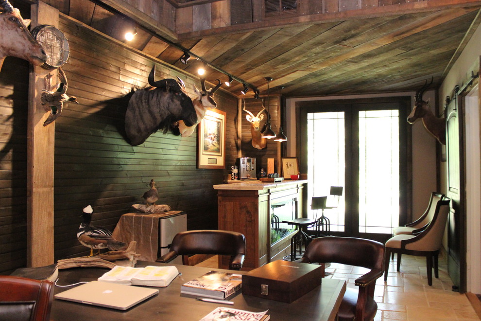 На фото: кабинет среднего размера в стиле рустика с коричневыми стенами, полом из травертина и отдельно стоящим рабочим столом