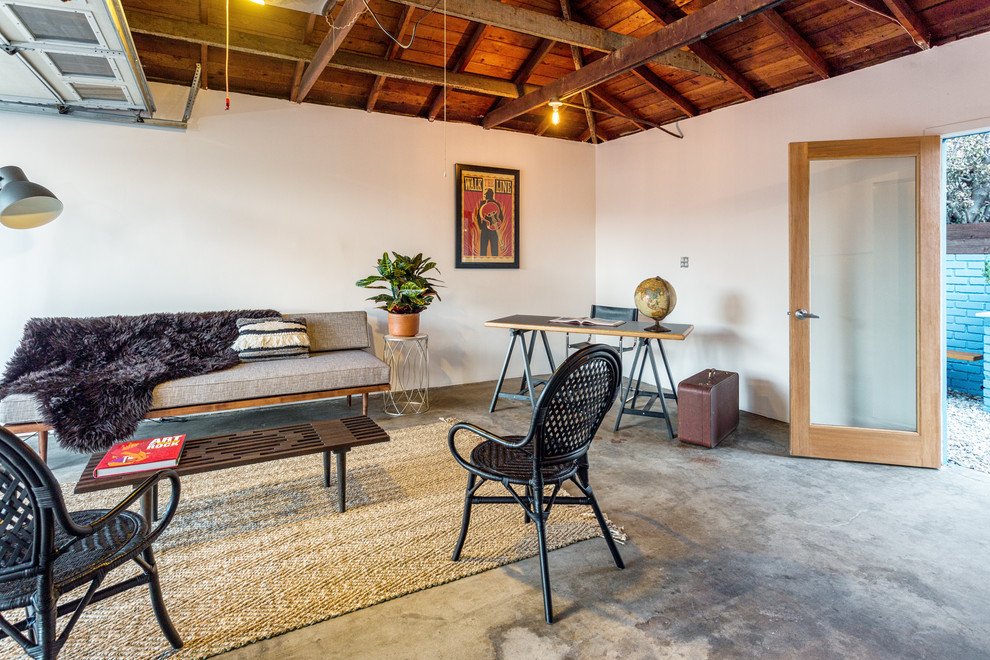 Foto de estudio contemporáneo grande con paredes blancas, suelo de cemento y escritorio independiente
