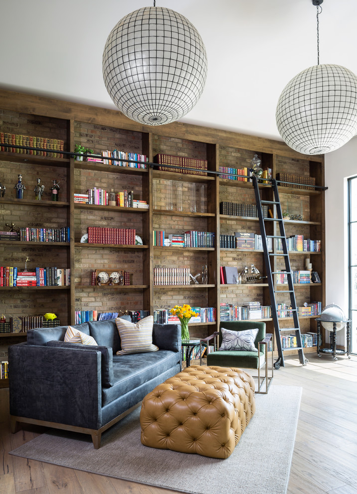 Foto på ett mycket stort eklektiskt arbetsrum, med ett bibliotek, vita väggar, mellanmörkt trägolv och brunt golv