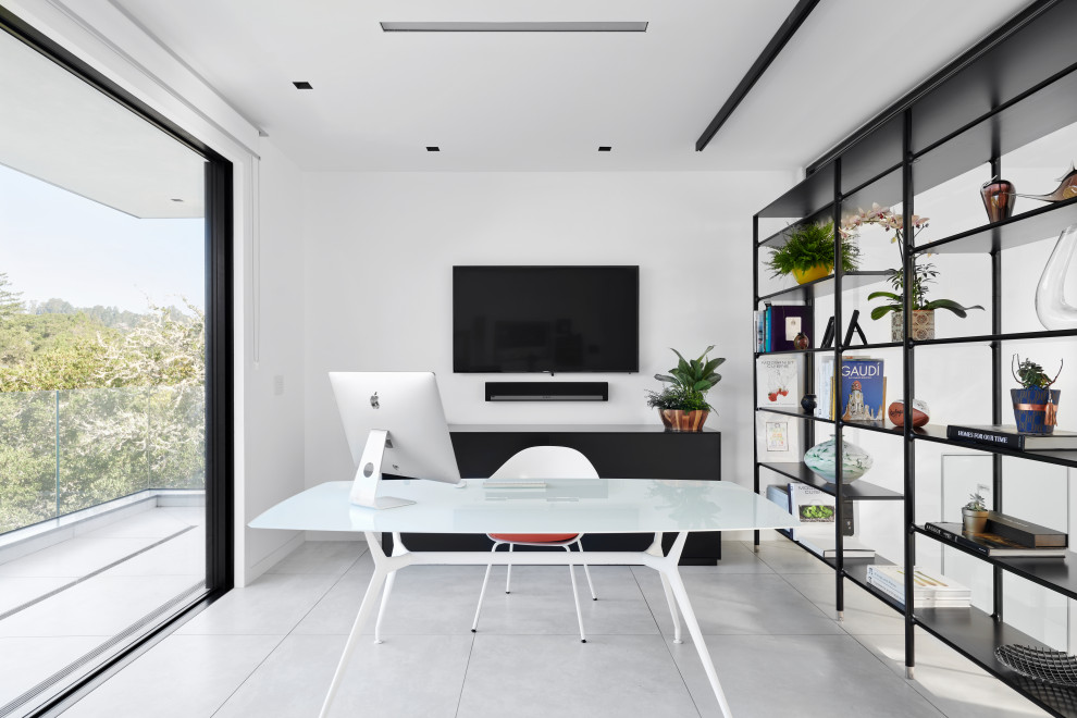 Ejemplo de despacho contemporáneo de tamaño medio con paredes blancas, suelo de baldosas de porcelana, escritorio independiente y suelo gris