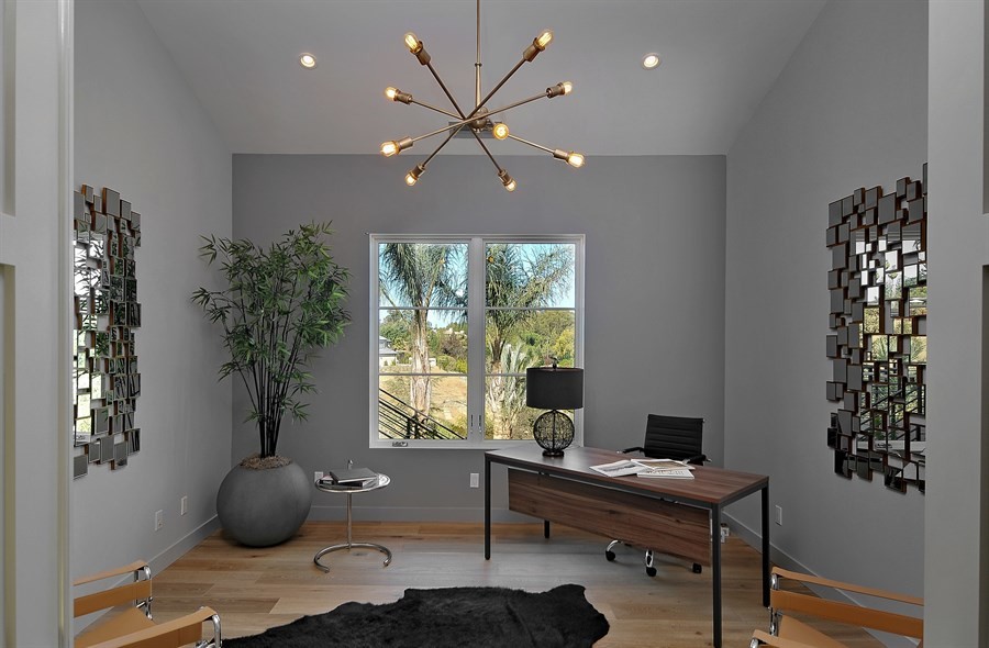 Exempel på ett modernt arbetsrum, med grå väggar, mellanmörkt trägolv och ett fristående skrivbord
