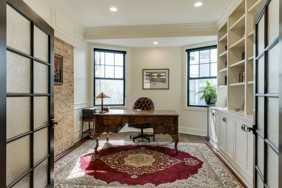 Imagen de despacho tradicional con paredes blancas, suelo de madera en tonos medios, escritorio independiente y suelo marrón