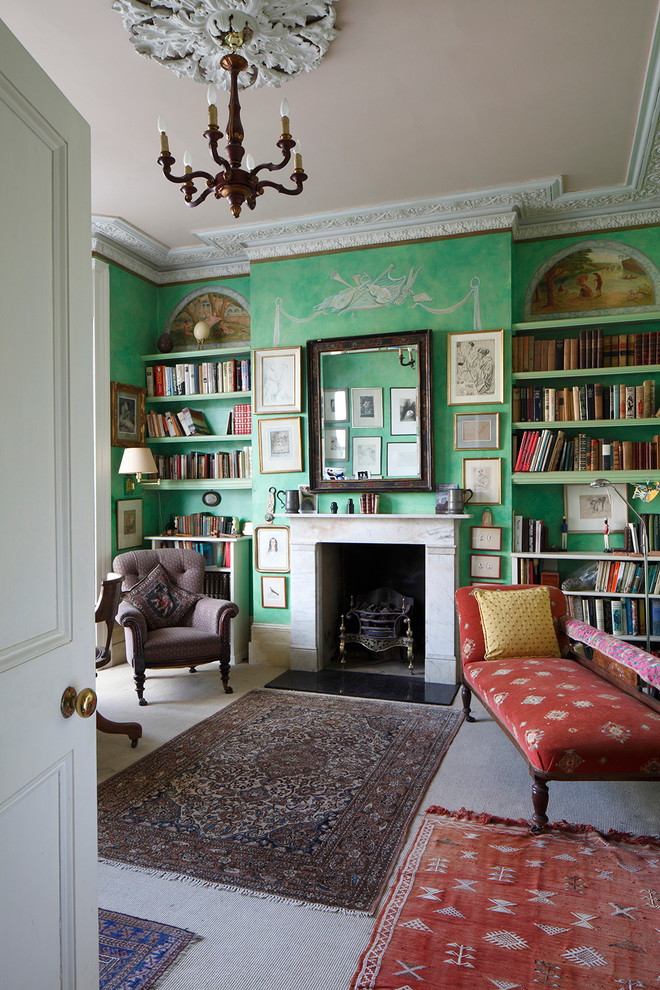 Idee per uno studio chic con libreria, pareti verdi, moquette e camino classico