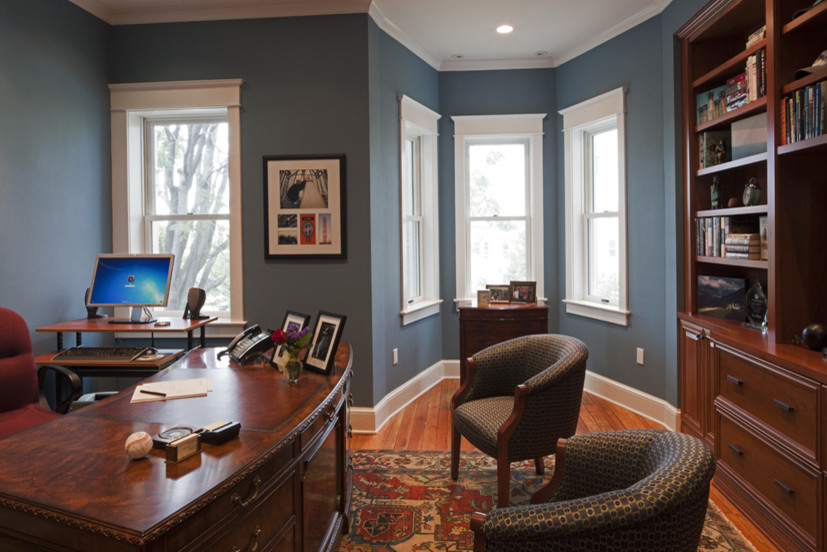 Imagen de despacho tradicional de tamaño medio con paredes azules, suelo de madera en tonos medios y escritorio independiente