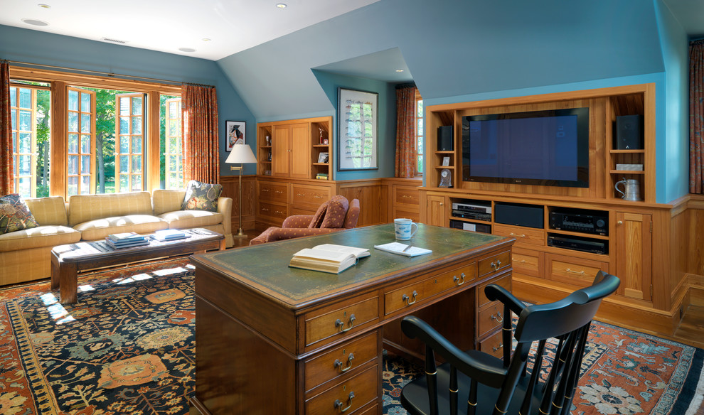 Großes Klassisches Arbeitszimmer mit Arbeitsplatz, blauer Wandfarbe, braunem Holzboden, freistehendem Schreibtisch und braunem Boden in Boston
