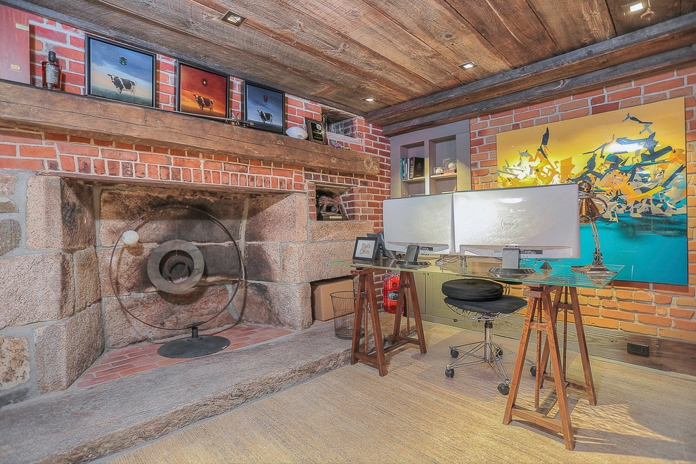 ニューヨークにあるインダストリアルスタイルのおしゃれなホームオフィス・書斎 (標準型暖炉、石材の暖炉まわり、自立型机) の写真