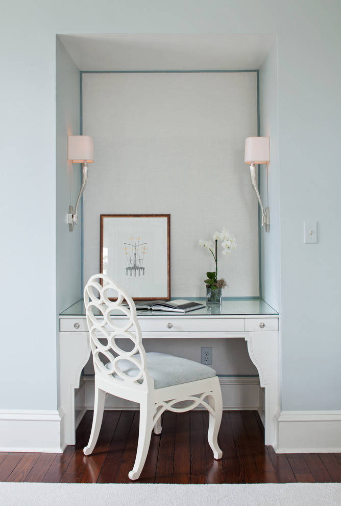 Ejemplo de despacho tradicional pequeño con paredes azules, suelo de madera oscura y escritorio empotrado