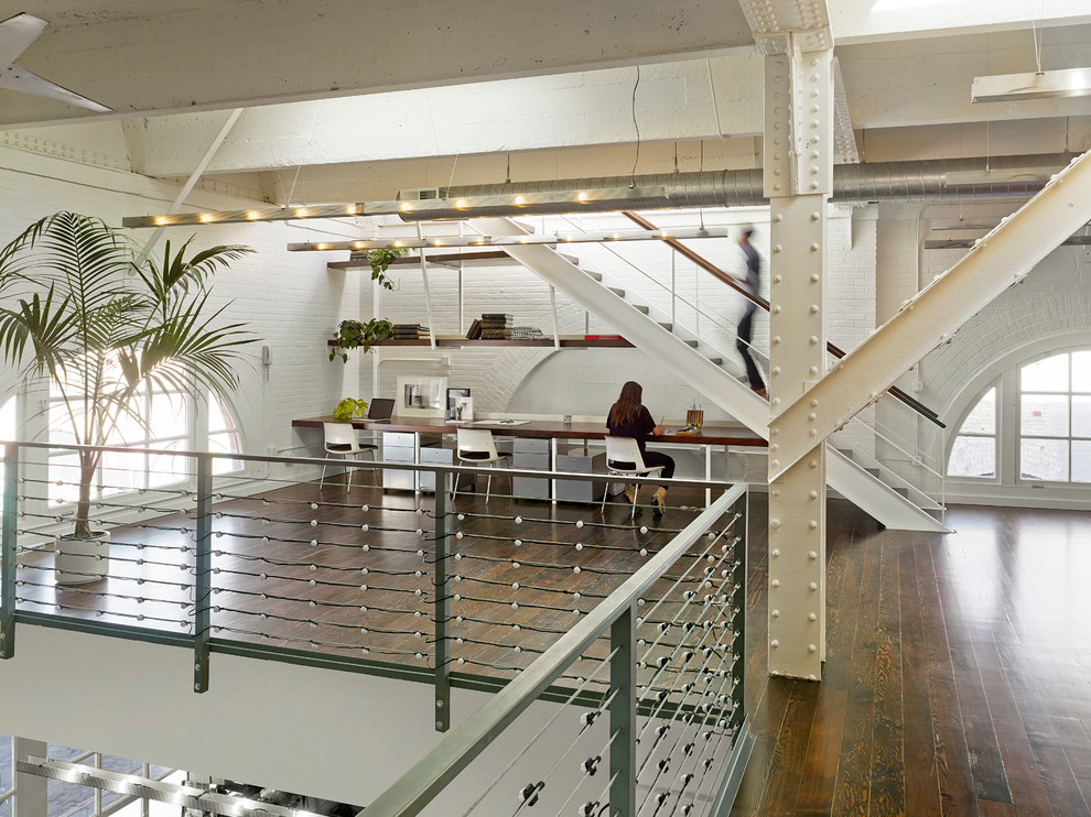 Großes Industrial Arbeitszimmer mit Studio, weißer Wandfarbe, braunem Holzboden und Einbau-Schreibtisch in San Francisco