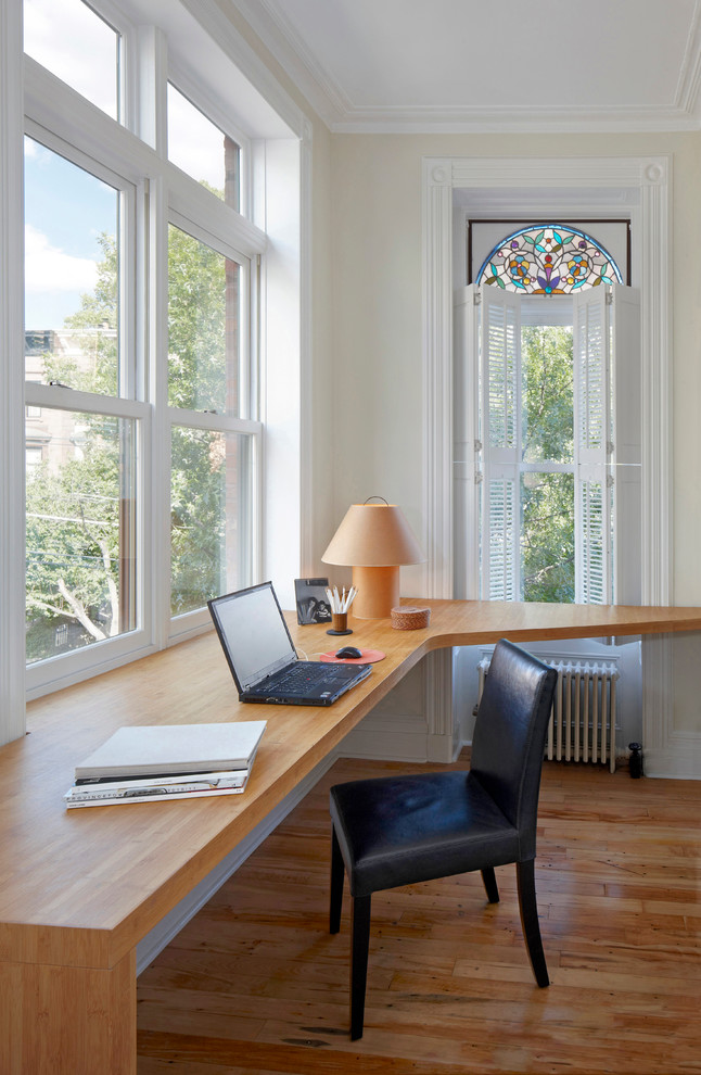 Immagine di un ufficio chic con pareti beige, pavimento in legno massello medio e scrivania incassata