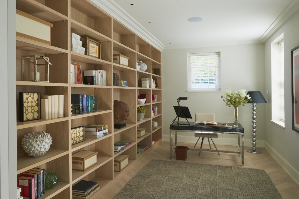 Modelo de despacho clásico renovado con paredes grises, suelo de madera clara y escritorio independiente