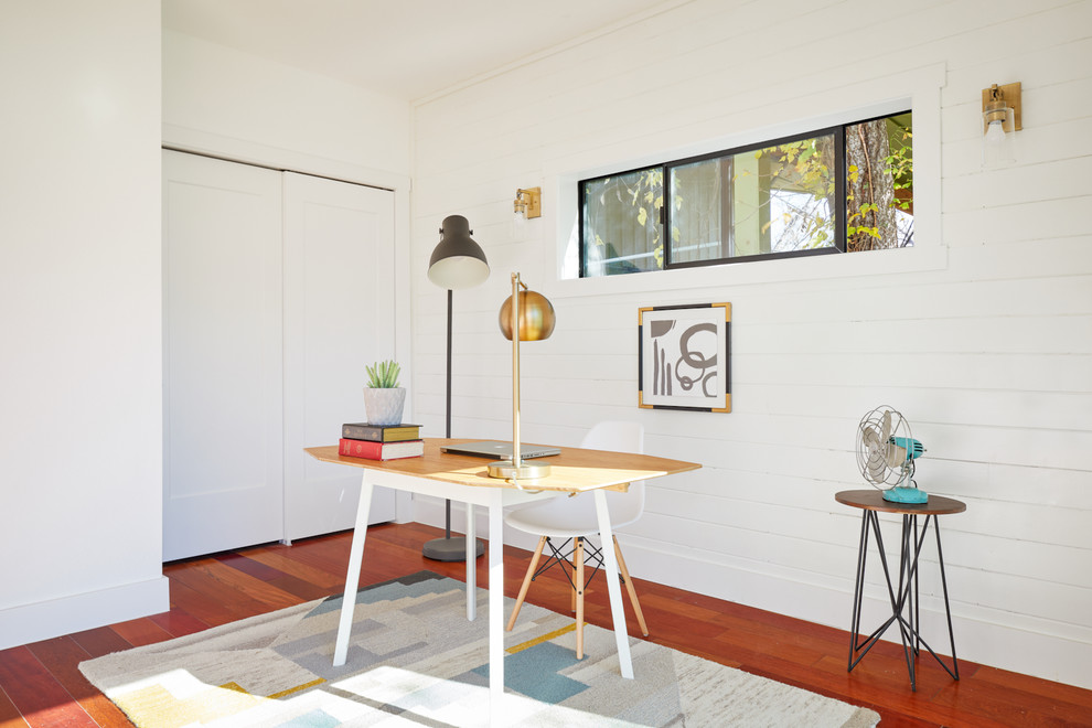Idée de décoration pour un petit bureau minimaliste avec un mur blanc et un sol en bois brun.