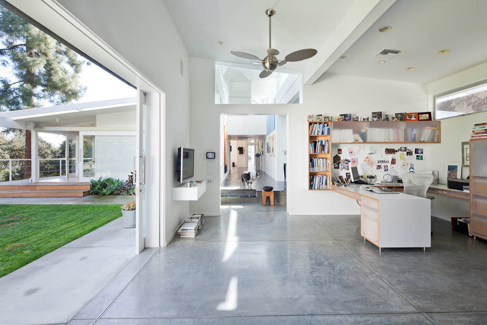 Home office - mid-sized 1950s built-in desk concrete floor and gray floor home office idea in Los Angeles with white walls