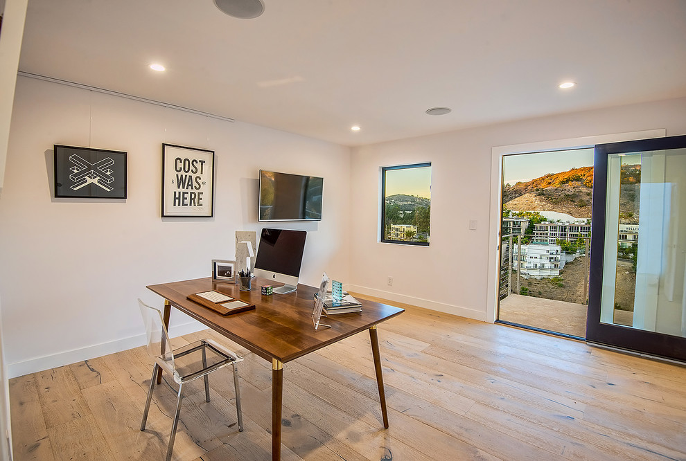 Photo of a medium sized contemporary study in Los Angeles with white walls, light hardwood flooring, no fireplace and a freestanding desk.