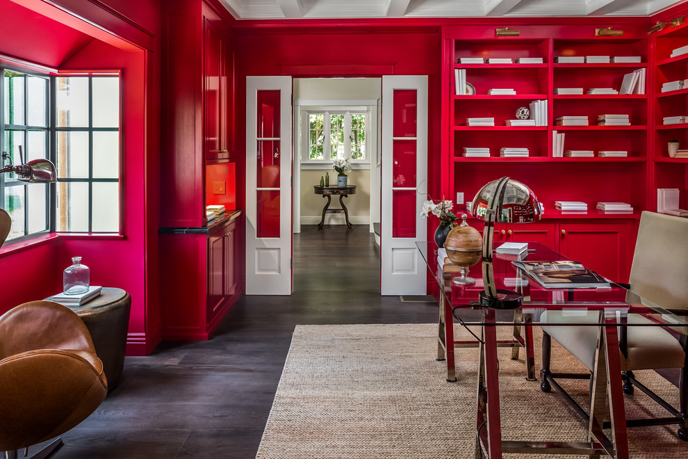 Cette image montre un grand bureau traditionnel avec un mur rouge, parquet foncé, aucune cheminée, un bureau indépendant et un sol marron.