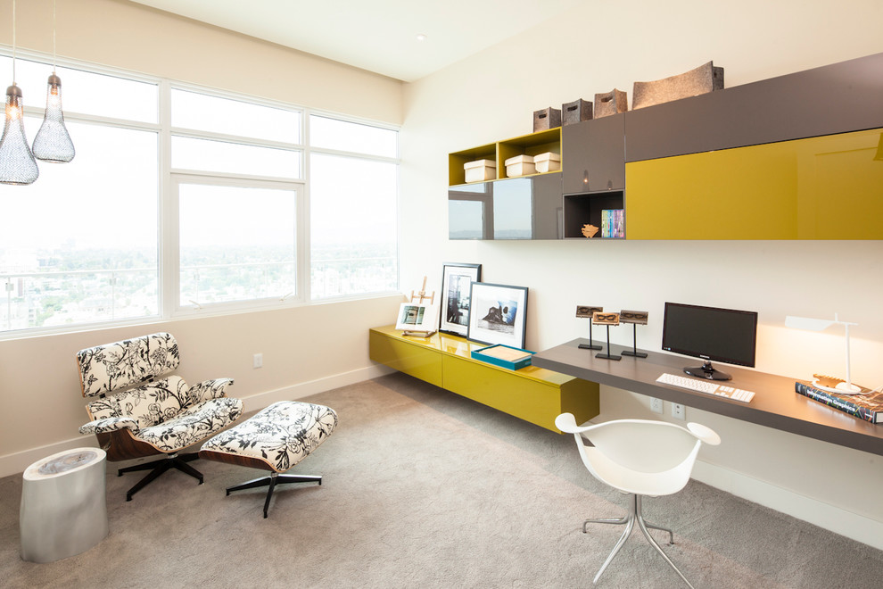 Modernes Arbeitszimmer mit beiger Wandfarbe, Teppichboden, Einbau-Schreibtisch und grauem Boden in Los Angeles