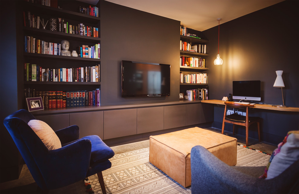This is an example of a medium sized contemporary home office in London with a reading nook, purple walls, concrete flooring, no fireplace and a built-in desk.