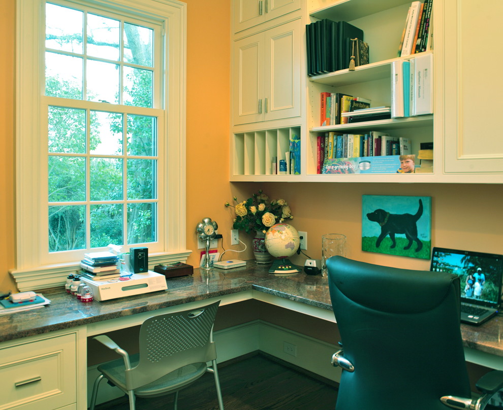 Idée de décoration pour un bureau tradition de taille moyenne avec un mur jaune, parquet foncé, aucune cheminée et un bureau intégré.